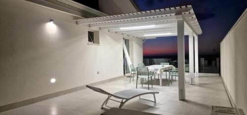 a dining room with a table and chairs on a balcony at Villa Taliala in Alcamo Marina