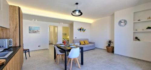 a kitchen and a living room with a table and chairs at Villa Taliala in Alcamo Marina