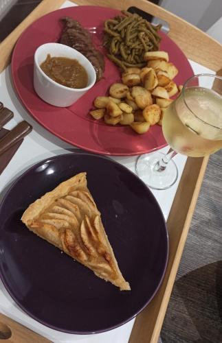 a table with two plates of food and a glass of wine at L'Heure Bleue gîtes et chambres d'hôtes in Givenchy-en-Gohelle
