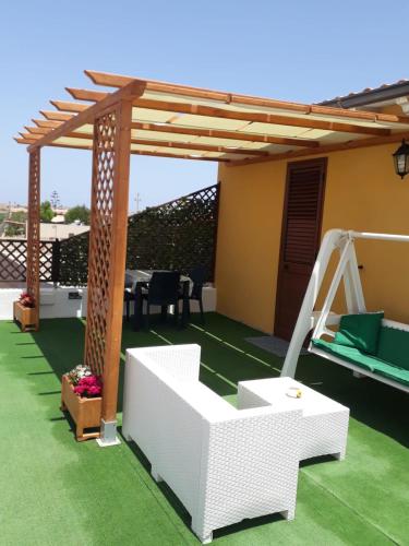 een patio met een pergola en een schommel bij Appartamento Domenico in Lampedusa