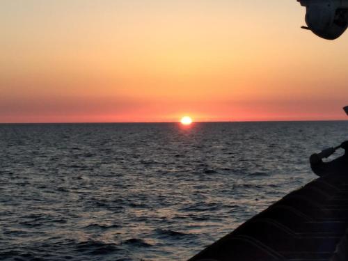 una puesta de sol en un barco en el océano en Appartamento Domenico, en Lampedusa