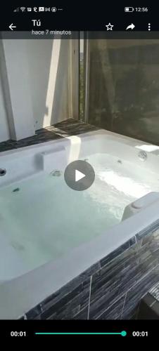 a bathtub with a window with a black letter on it at Casa Versace Tequesquitengo in Tequesquitengo