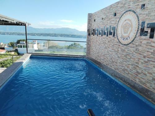 a large blue swimming pool next to a brick building at Casa Versace Tequesquitengo in Tequesquitengo