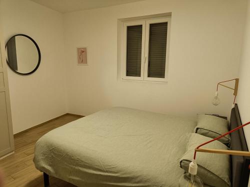 ein kleines Schlafzimmer mit einem Bett und einem Spiegel in der Unterkunft Apartment near to Como - Donkey's House in Tavernerio