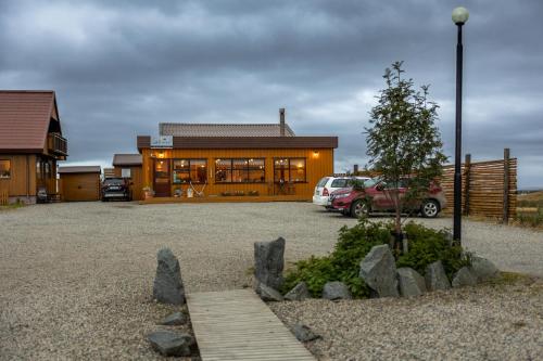 une maison avec une voiture garée devant elle dans l'établissement Árnanes Country Hotel, à Höfn