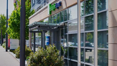 a glass facade of a building with a sign on it at Holiday Inn Express Frankfurt Messe by IHG in Frankfurt/Main