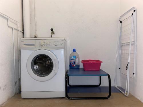 a washing machine with a small table next to it at Les Oliveres - casa- apartament in Vilafant