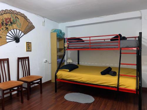 a bedroom with a bunk bed and two chairs at Les Oliveres - casa- apartament in Vilafant
