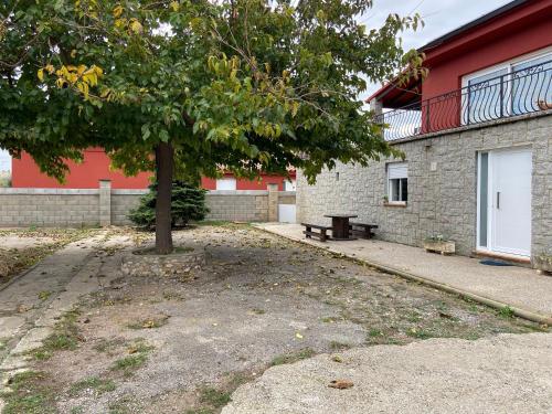 a tree in front of a building with a bench at Les Oliveres - casa- apartament in Vilafant