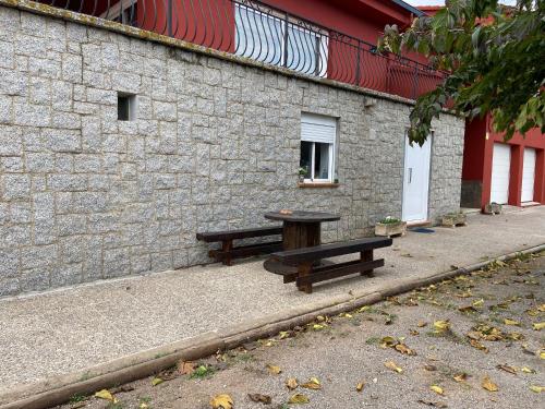 two benches sitting in front of a brick building at Les Oliveres - casa- apartament in Vilafant
