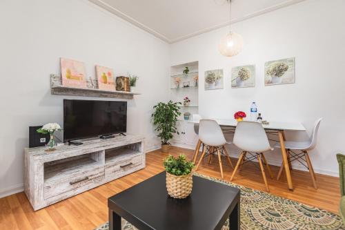 a living room with a tv and a table and chairs at Cosy Apartment with Veranda in Gaia - 1E in Vila Nova de Gaia