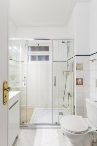 a white bathroom with a shower and a toilet at Nice Apartment with Veranda in Gaia - 3D in Vila Nova de Gaia