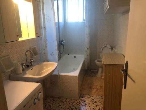łazienka z umywalką, wanną i toaletą w obiekcie MARIAS APARTMENT SMART KEY BOX by PROJECT 86 IKE w mieście Agrinio