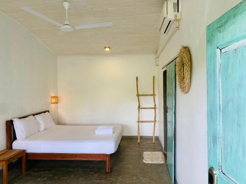a bedroom with a white bed and a wooden chair at Sky Breeze in Unawatuna