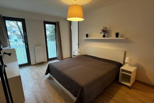 Residence Garden Tower - zimni zahrada في براغ: غرفة نوم مع سرير في غرفة مع نوافذ