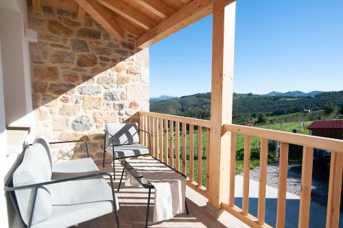 a balcony with two chairs and a view of the mountains at La Asomada de Vidular in Bárcena de Cicero