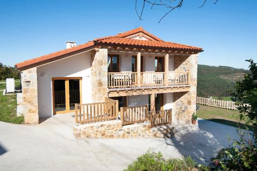 a small house with a balcony and a porch at La Asomada de Vidular in Bárcena de Cicero
