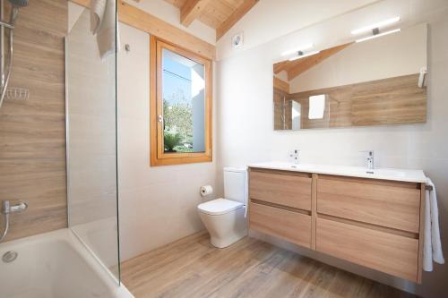 a bathroom with a toilet and a sink and a shower at La Asomada de Vidular in Bárcena de Cicero