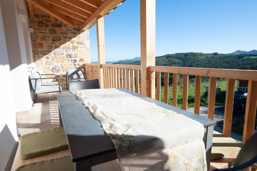 a porch with a table and chairs on a balcony at La Asomada de Vidular in Bárcena de Cicero