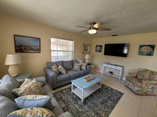 een woonkamer met een bank en een flatscreen-tv bij Beachy Sarasota Duplex in Sarasota