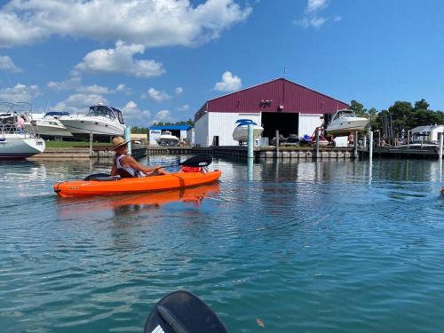 a man in an orange kayak in the water at Modern Beach House long stay discounts in Sarnia