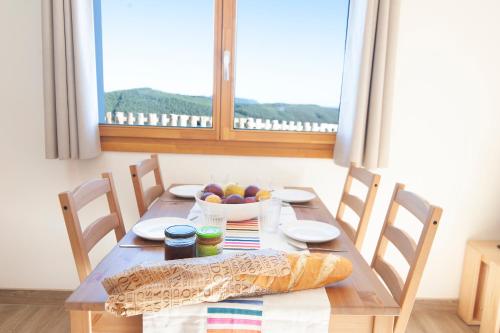 a wooden table with a bowl of fruit and a window at La Asomada de Vidular in Bárcena de Cicero