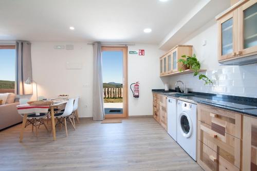 a kitchen with a table and a dining room at La Asomada de Vidular in Bárcena de Cicero
