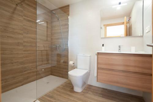 a bathroom with a toilet and a glass shower at La Asomada de Vidular in Bárcena de Cicero