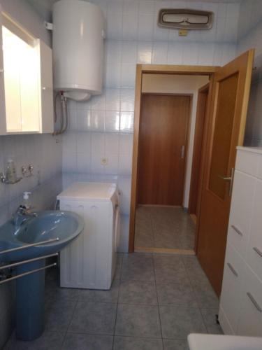 a bathroom with a sink and a washer and dryer at Apartment Meri in Trogir