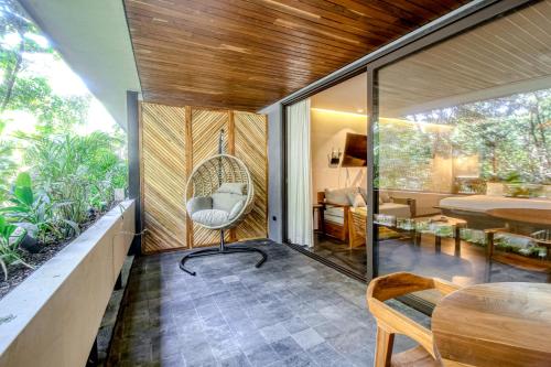 a room with a swing chair in a house at Miraluna 233 at Luum Zama in Tulum
