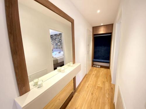 ein Badezimmer mit einer Theke und einem großen Spiegel in der Unterkunft Lux Apartment Ski&Golf in Kranjska Gora