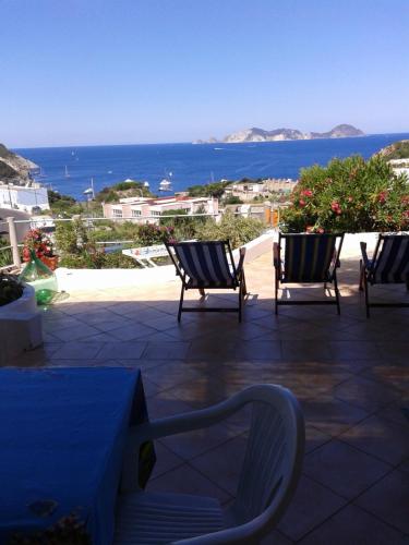 two chairs sitting on a patio with a view of the ocean at Casadelpino Residence La Piana in Ponza