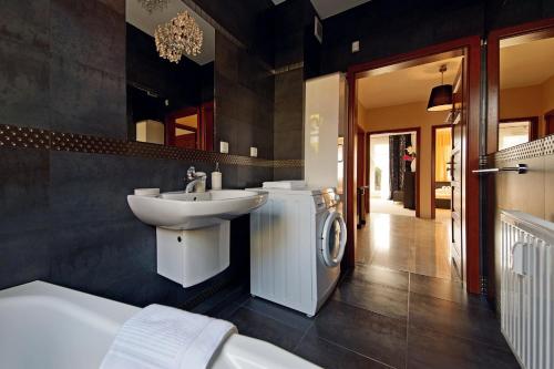 a bathroom with a sink and a washing machine at Glamour Apartments Sopot in Sopot