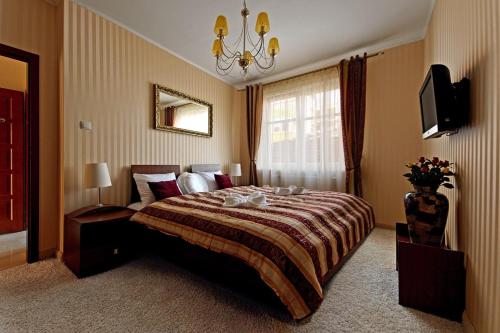 a bedroom with a large bed and a chandelier at Glamour Apartments Sopot in Sopot