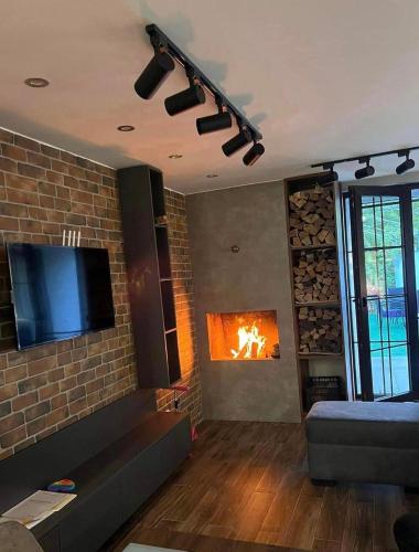 a living room with a tv and a fireplace at Likani Home in Borjomi