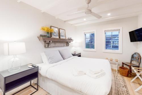 1 dormitorio blanco con 1 cama blanca y TV en Modern Harbor Retreat, en Rockland