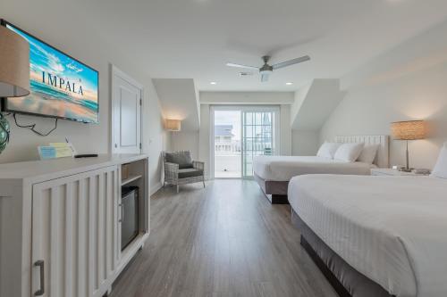 a hotel room with two beds and a flat screen tv at Impala Suites in Ocean City