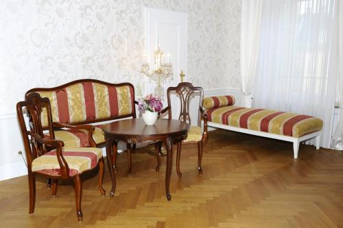 a living room with a couch and a table and chairs at HELIOPARK Bad Hotel Zum Hirsch in Baden-Baden