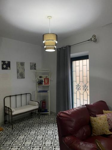 a living room with a couch and a window at Casa rural Hnas Corral in Almoharín