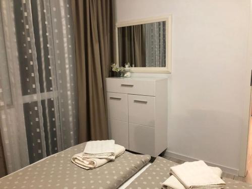 a bedroom with a bed with a dresser and a mirror at Varna Sea Residence in Varna City
