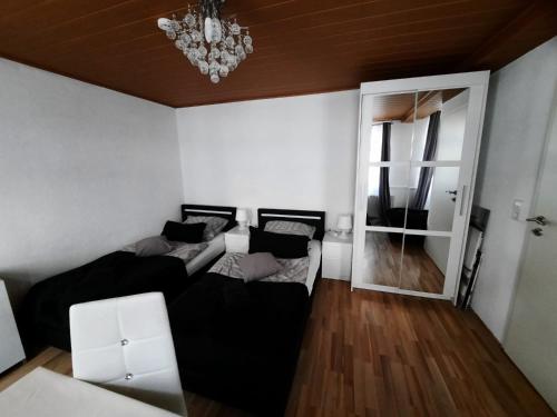 a living room with two beds and a chandelier at Ferienwohnungen Calwer Höfle City - für Firmen, Handwerker und Monteure in Calw