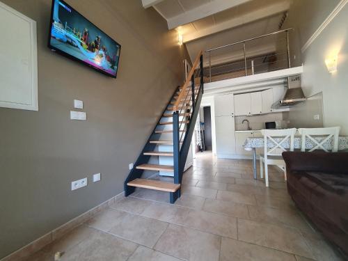 a staircase in a living room with a tv on the wall at La Bastide Bleue in Anduze