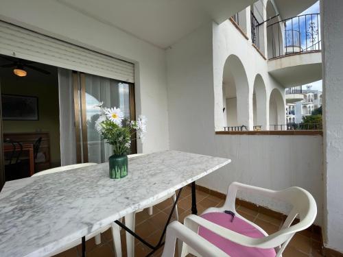 ペニスコラにあるAlpen1 Residencial Finca del Moroの白い椅子2脚付きテーブル、花瓶