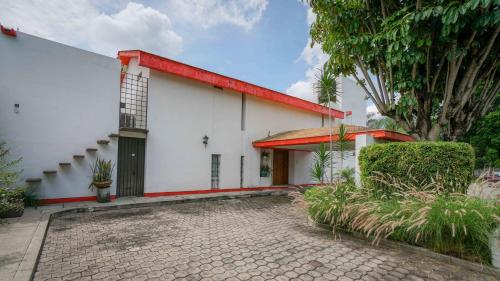 un edificio blanco con techo rojo en Casa Fujiyama Relax y Alberca bajo el sol, en Cuernavaca