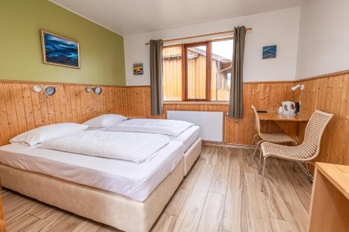a bedroom with a bed and a desk and a window at Árnanes Country Hotel in Höfn