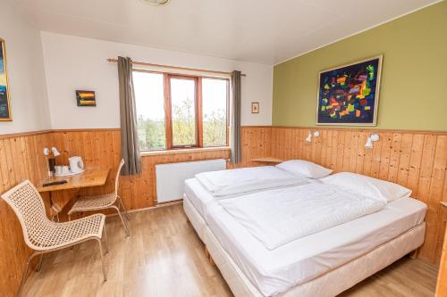 a bedroom with a bed and a desk and a table and chairs at Árnanes Country Hotel in Höfn