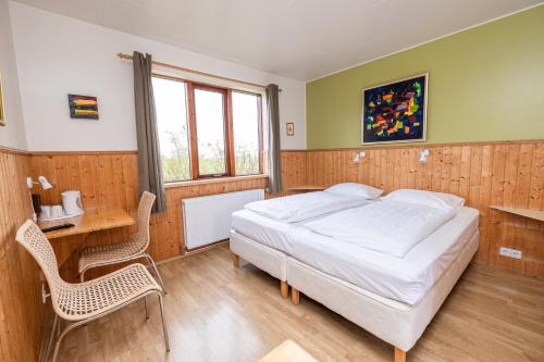 a bedroom with a bed and a table and chairs at Árnanes Country Hotel in Höfn