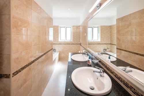 a bathroom with two sinks and a mirror at Casa Guincho in Carvoeiro
