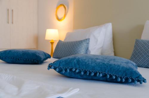 a bed with blue pillows on top of it at Lefka Ori in Khóra Sfakíon