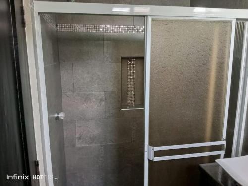 a shower with a glass door in a bathroom at Lindo apartamento in Daule
